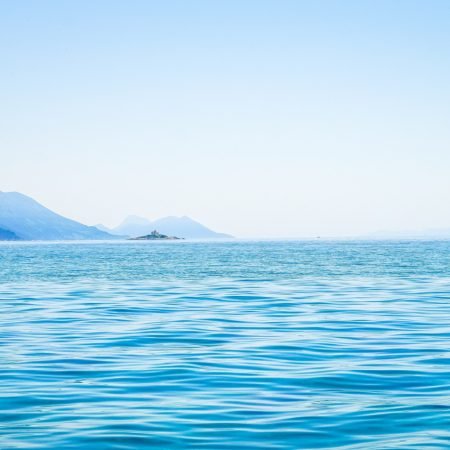 beautiful-shot-sea-with-mountain-distance-clear-sky